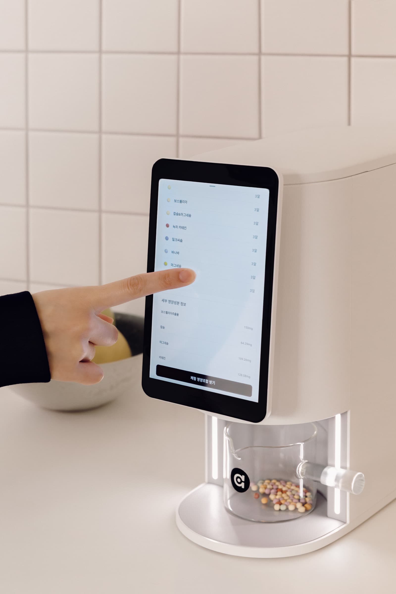 Hand reviewing today's personalized mix on the E1 tablet screen.