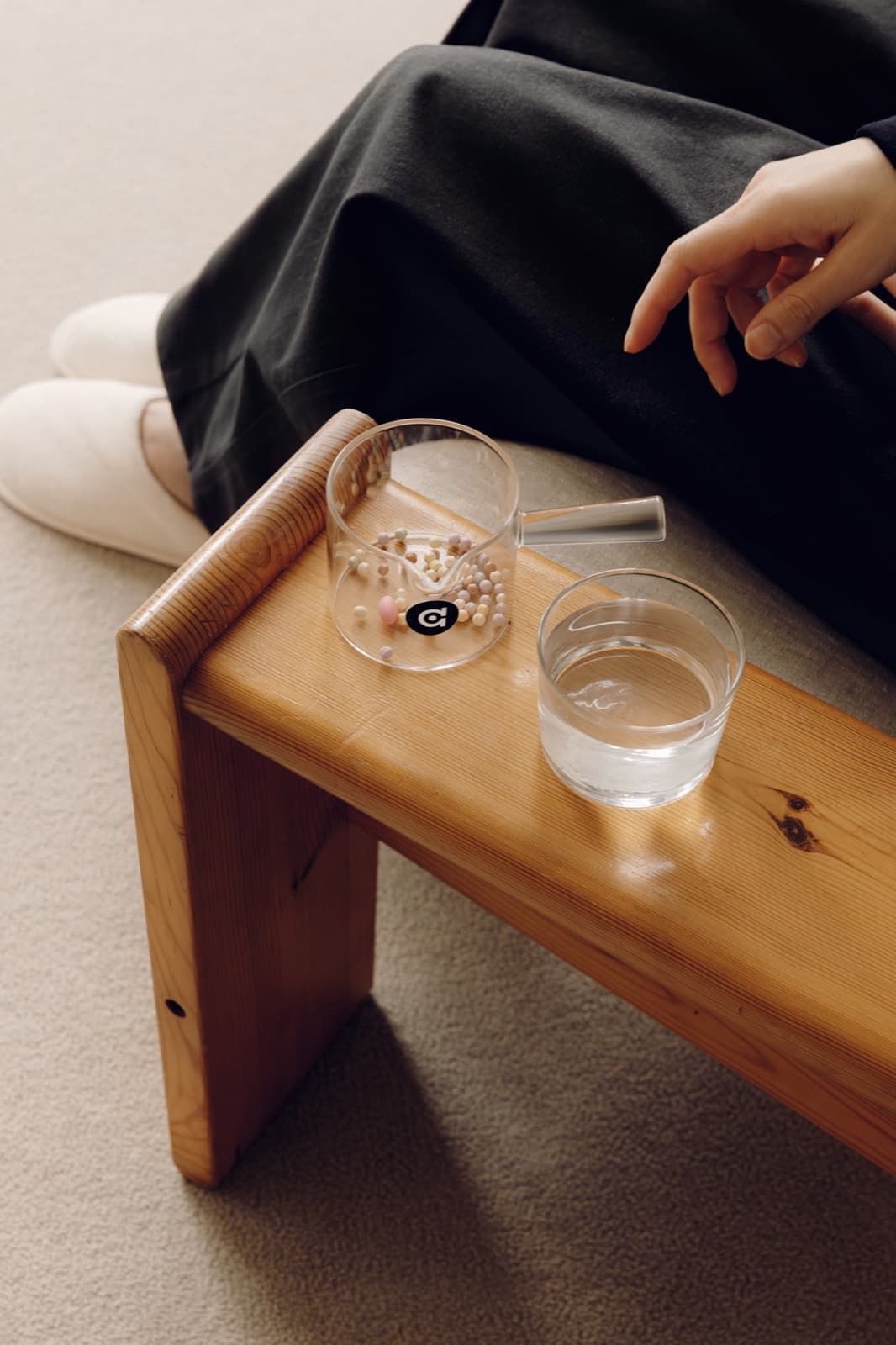 Glass cup with a daily mix of beads beside the E1 dispenser — the 'after' scene.